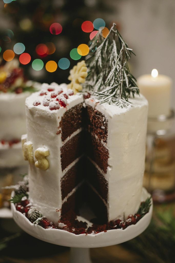 Tasty chocolate cake with red berries and fresh herb sprigs during New Year holiday at home